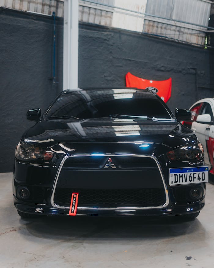 Front view of a sleek black Mitsubishi Lancer parked indoors in a garage setting.
