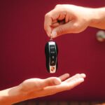 Close-up of hands exchanging a luxury car key in São Paulo, Brazil.
