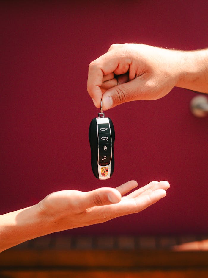 Close-up of hands exchanging a luxury car key in São Paulo, Brazil.